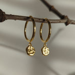 Designed by Megan Collins, the "Balance Hoops" are made to be worn as a reminder that life's beauty lies in the balance between hard work and play.